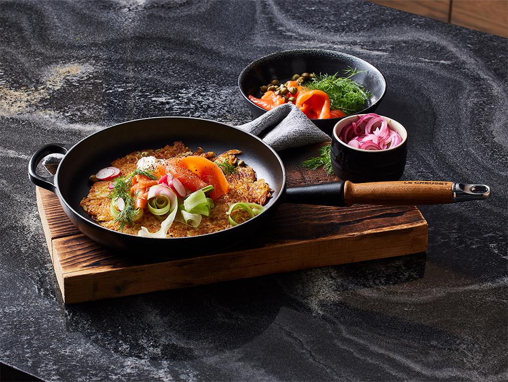 Oranje zoete eenpansaardappelrösti met gerookte zalm en crème fraîche